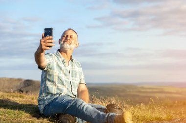 Mavi tişörtlü sakallı bir gezgin Peak District 'teki dağları tavlıyor. Yerel turizm yaşam tarzı konsepti.
