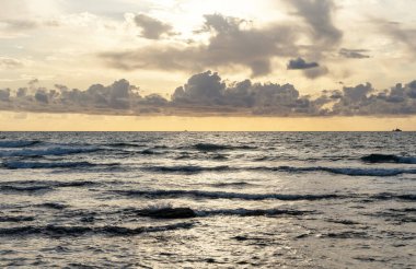 Yazın kayalık sahilde güzel bir gün batımı