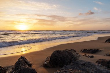 Yazın kayalık sahilde güzel bir gün batımı