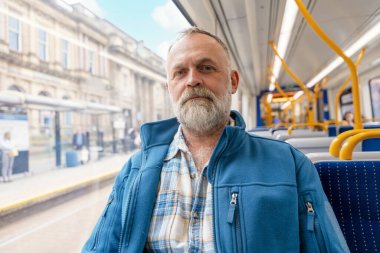 Otobüste mavi ceketli gülümseyen sakallı bir adamın portresi. Yaşam tarzı kavramı