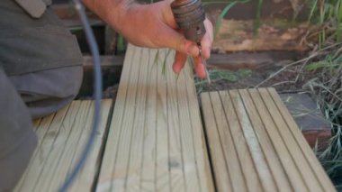 Erkek müteahhit vida sürmek için elektrikli tornavida kullanıyor.