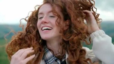 Heyecanlı ceketli kadın varış noktasına ulaşıyor ve selfie çekiyor, gün batımında dağın tepesinde telefonla sohbet ediyor. Seyahat yaşam tarzı farklı duygular ve duygu konsepti