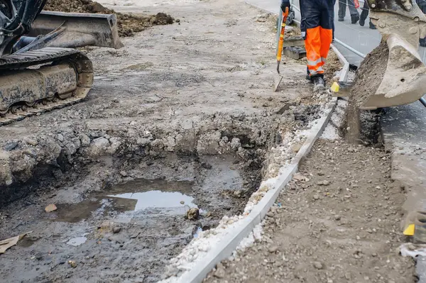A new footpath is under construction as builders bring stone, levelling and compacting it