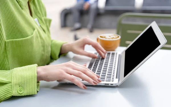 woman having coffee at the street cafe outside, talking on the laptop and having fun time. lifestyle concept