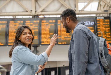 Tren istasyonundaki genç aile, zaman çizelgesinin önünde ilerleyen seyahatler için dışarı çıktılar.