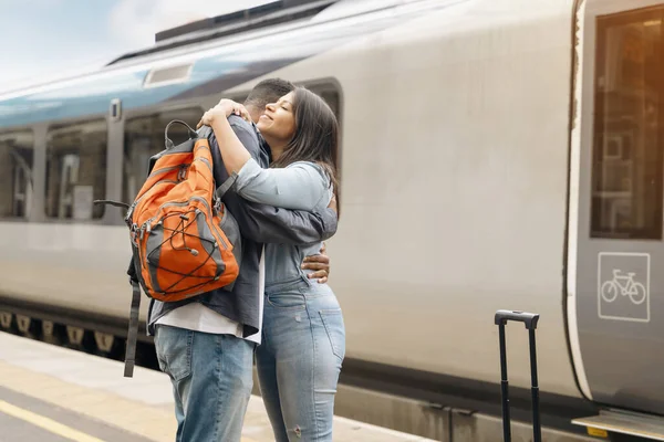 a young beautiful couple embraces on the platform meeting, saying goodbye  the spouse, friend. Travel  lifestyle concept