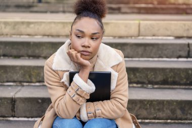 Mutsuz bir kadın öğreniyor, okuyor, ders çalışıyor şehrin merdivenlerinde oturuyor. Eğitim kavrayışı