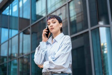 Cep telefonuyla konuşan genç bir kadının portresi.