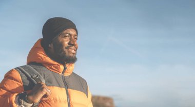 Sırt çantalı mutlu turist İngiltere 'de gün batımında dağ manzarası seyrediyor. Sırt çantasıyla dağlara yolculuk. Yürüyüşün ve yeni yerler keşfetmenin tadını çıkarın.