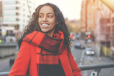 Şehrin sokaklarında yürüyen ve güneşli günün tadını çıkaran çekici genç bir kadının yüz portresi.