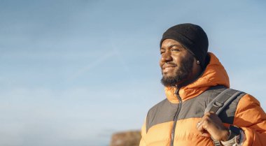 Sırt çantasıyla gezen ve İngiltere 'de gün batımında dağların tadını çıkaran yakışıklı turist. Sırt çantasıyla dağlara bir gezi. Yürüyüşün ve yeni yerleri keşfetmenin tadını çıkar.