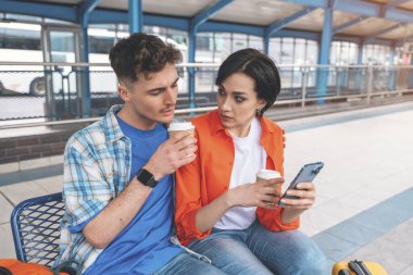 Balayı boyunca birlikte seyahat eden, Kavşak 'ta oturan, otobüs bekleyen, kahve içen, sohbet eden, haber okuyan genç bir çift. Birlikte seyahat konsepti