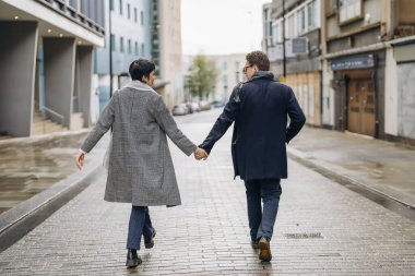 Yakışıklı bir adam ve güzel bir kadın şehirde yürürken birbirlerine sarılıyorlar, eğlenceli vakit geçiriyorlar, yaşam tarzı fotoğrafı çekiyorlar.