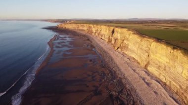 Güzel güneş Galler 'de kışın kayalık kıyılarda doğar.