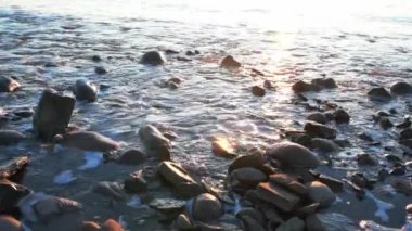 Galler 'de kışın kayalık sahilde güzel bir gün doğumu.