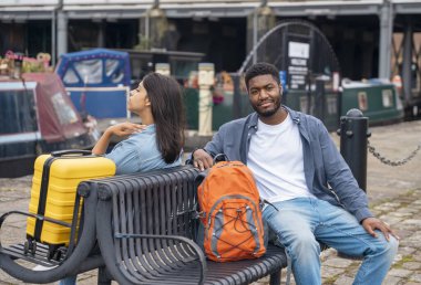 Sırt çantalı ve bavullu çift rıhtımda yürüyor ve sarılıyor, yat, yelkenli, tekne bakıyor, eğleniyor, flört ediyor. Yaşam tarzı kavramı