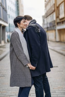 Yakışıklı bir adam ve güzel bir kadın şehirde yürürken birbirlerine sarılıyorlar, sokakta dans ediyorlar, eğleniyorlar, yaşam tarzı fotoğrafları çekiyorlar.