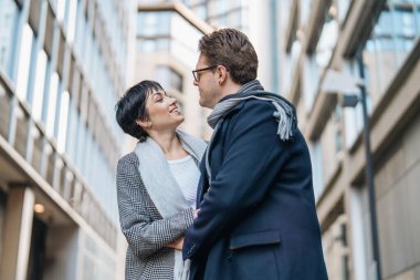 Yakışıklı bir adam ve güzel bir kadın şehirde yürürken birbirlerine sarılıyorlar, sokakta dans ediyorlar, eğleniyorlar, yaşam tarzı fotoğrafları çekiyorlar.