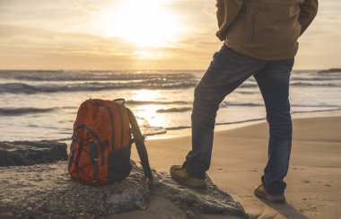 Sakallı Adam gün batımında sıcak güneşli bir günde deniz kenarında tek başına dinleniyor. Seyahat yaşam tarzı konsepti