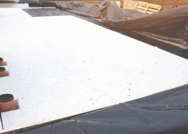 Su geçirmez zar ve zemin altı yalıtımı inşaat işçileri tarafından yeni bir konut inşaatı sırasında iç drenaj boruları kesilerek yerleştiriliyor.