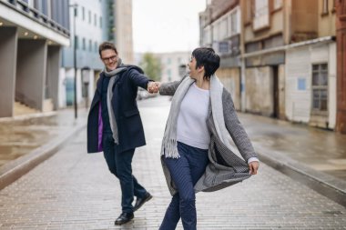 Yakışıklı erkek ve güzel kadın şehirde yürürken birbirlerine sarılıyorlar, eğleniyorlar, hayat tarzı fotoğraf çekiyorlar.