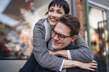 Yakışıklı erkek ve güzel kadın şehirde yürürken birbirlerine sarılıyorlar, eğleniyorlar, hayat tarzı fotoğraf çekiyorlar.