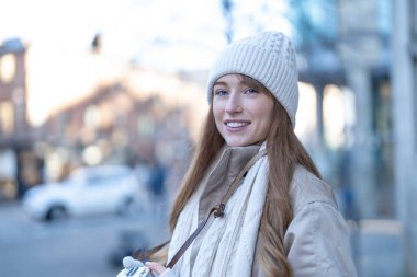 Gülümseyen genç bir kadının portresi Noel pazarında eğleniyor, şehir merkezindeki açık havada telefonları kullanıyor. insanlar, iletişim, alışveriş ve yaşam tarzı kavramı