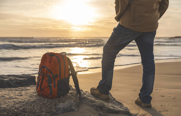 Бородатый человек отдыхает один на берегу моря в жаркий солнечный день на закате. Концепция Travel Lifestyle