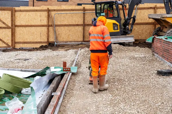 stock image New house and private parking space driveway construction. Builder levelin and compacting stone using plate compactor