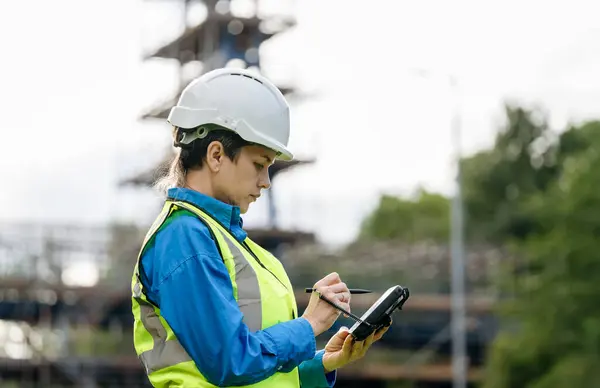 stock image Female site engineer surveyor working with theodolite total station EDM equipment on a building construction site outdoors