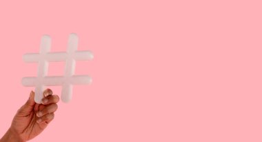 Elinde pembe arka planda fotokopi alanı olan bir etiket tutan kadın. İnternet konseptiyle ilgili sosyal medya, blog yazma ve viral konular