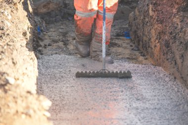 Somut döküm işi. İnşaatçı ıslak betonu dümdüz ediyor. İnşaat alanında beton işi var.