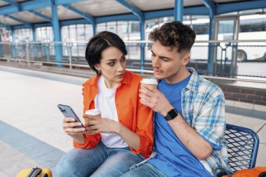 Balayı boyunca birlikte seyahat eden, Kavşak 'ta oturan, otobüs bekleyen, kahve içen, sohbet eden, haber okuyan genç bir çift. Birlikte seyahat konsepti