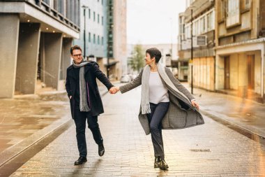Yakışıklı erkek ve güzel kadın şehirde yürürken birbirlerine sarılıyorlar, eğleniyorlar, hayat tarzı fotoğraf çekiyorlar.