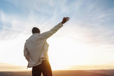 Sırt çantasıyla gezen ve İngiltere 'de gün batımında dağların tadını çıkaran yakışıklı turist. Sırt çantasıyla dağlara bir gezi. Yürüyüşün ve yeni yerler keşfetmenin tadını çıkarın.