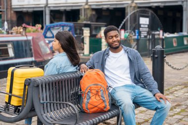 Sırt çantalı ve bavullu çift rıhtımda yürüyor ve sarılıyor, yat, yelkenli, tekne bakıyor, eğleniyor, flört ediyor. Yaşam tarzı kavramı