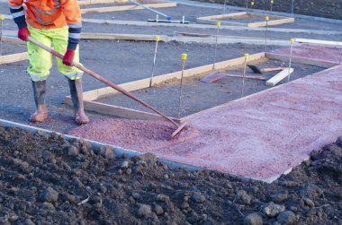 Yeni patika inşaatı sırasında inşaat işlerinin içine ıslak ve hazır karışımı beton döken ve döken inşaatçılar