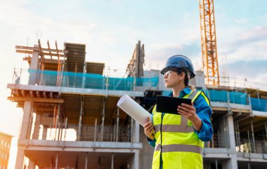 Bir inşaat şantiyesinde Theodolite toplam istasyon EDM ekipmanıyla çalışan kadın inşaat mühendisi araştırmacısı.
