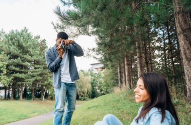 Yakışıklı bir adam ve güzel bir kadın birbirlerine sarılıyorlar, aşık oluyorlar ve parkta birlikte vakit geçiriyorlar.