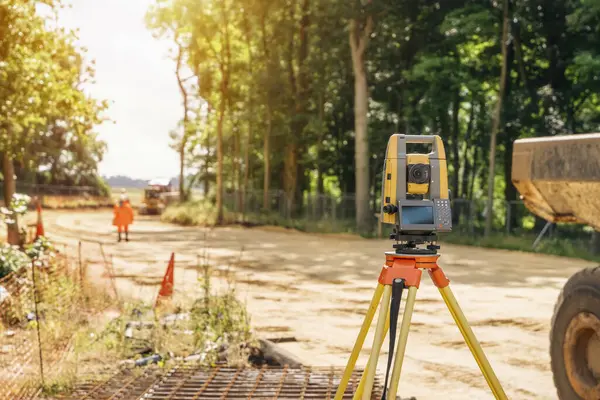 İnşaat alanındaki yol çalışmaları sırasında bir mühendis tarafından kurulmuş teodolit ya da tacheometre ekipmanlarının incelenmesi