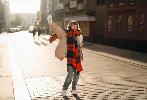 stock image smiling happy young woman student having a fun time and walking around city at sunset