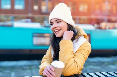 Gülümseyen genç bir kadının portresi dışarıda eğleniyor, telefon kullanıyor, şehir dışında video çekiyor. insanlar, iletişim, alışveriş ve yaşam tarzı kavramı