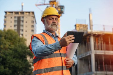 Bir inşaat şantiyesi inşaatında Theodolite toplam EDM ekipmanlarıyla çalışan bir inşaat mühendisi.