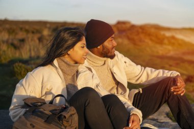 Aşık mutlu çift gün batımında kırsalda yürüyor. Aşk, yürüyüş ve aktif yaşam tarzı konsepti