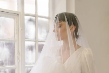 Şık düğün saç stili olan güzel bir gelin. Düğün için. Stüdyo çekimi. Yüzünde peçeyle güzel bir gelin portresi