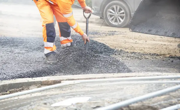 Kürekli müteahhit yola sıcak asfalt koyuyor.