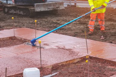Yeni patika inşaatı sırasında inşaat işlerinin içine ıslak ve hazır karışımı beton döken ve döken inşaatçılar