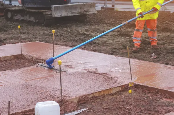 Yeni patika inşaatı sırasında inşaat işlerinin içine ıslak ve hazır karışımı beton döken ve döken inşaatçılar