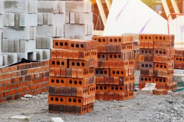 İnşaat alanına kırmızı tuğlalar ve beton bloklar getirildi ve tuğla yapımına hazır iş yerinin yanına yerleştirildi.