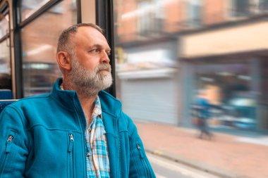 Otobüste ya da tramvayda telefonla konuşan mavi ceketli sakallı bir adamın portresi. Yaşam tarzı kavramı